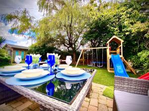 a table with chairs and a playground in a backyard at Beautiful Hot Tub Suite in Lytham St Annes in Lytham St Annes
