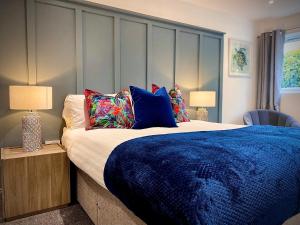 a bedroom with a large bed with blue sheets and pillows at Beautiful Hot Tub Suite in Lytham St Annes in Lytham St Annes