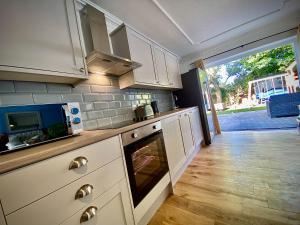 a kitchen with white cabinets and a stove top oven at Beautiful Hot Tub Suite in Lytham St Annes in Lytham St Annes