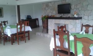comedor con chimenea, mesa y sillas en Hotel Campestre, en El Valle de Antón