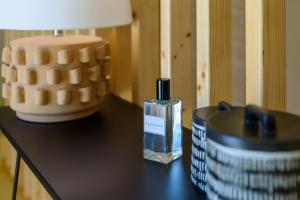 a bottle of perfume on a table next to a lamp at Sea'Ya Thoughtful Stays - Villas in Cascais