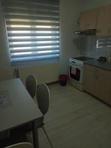 a kitchen with a table and a stove and a window at Apartman Žile in Bačka Palanka