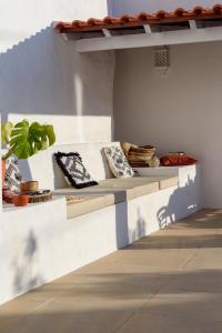 a white bench with pillows and a plant on it at Sea'Ya Thoughtful Stays - Villas in Cascais
