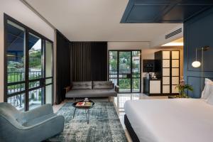 Hotel Botanica- Limited Edition By Fattal في حيفا: غرفة نوم مع سرير وغرفة معيشة