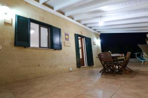 Una habitación con una mesa y sillas y ventanas. en Tenuta Ferilli, en Salve