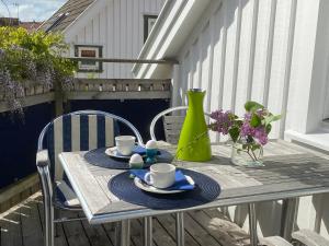 une table avec des tasses et des soucoupes sur un balcon dans l'établissement Bekvämt boende mitt i gamla genuina Skärhamn, à Skärhamn