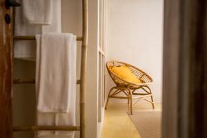 a wicker chair with a yellow pillow in a room at Sea'Ya Thoughtful Stays - Villas in Cascais