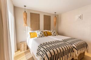 a bedroom with a large bed with colorful pillows at Sea'Ya Thoughtful Stays - Villas in Cascais