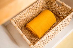 a wicker basket with a yellow towel in it at Sea'Ya Thoughtful Stays - Villas in Cascais