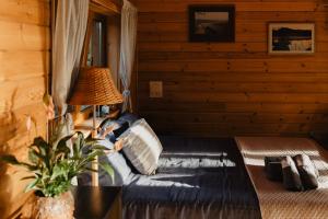 a bedroom with a bed in a log cabin at Beržų namelis - Birch cabin in Kučiūnai