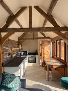 a kitchen with wooden ceilings and a wooden table at Beautiful countryside Byre conversion in Shrewsbury