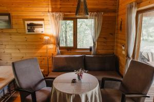 a living room with a table and chairs and a couch at Beržų namelis - Birch cabin in Kučiūnai