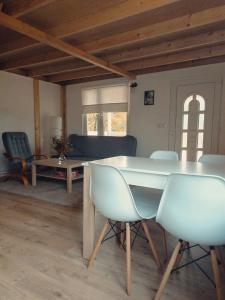 ein Wohnzimmer mit einem Tisch, Stühlen und einem Sofa in der Unterkunft Domek letniskowy na Kaszubach z Balia ogrodowa in Gowidlino