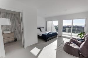 biała sypialnia z łóżkiem i kanapą w obiekcie Arrifana Sunset Sea View Villa w mieście Praia da Arrifana