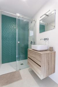 a bathroom with a sink and a glass shower at Arrifana Sunset Sea View Villa in Praia da Arrifana