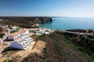 una vista aérea de una playa con edificios blancos y el océano en Arrifana Sunset Sea View Villa, en Praia da Arrifana