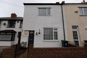 uma casa branca com uma porta preta e janelas em 3 bedroom home and garden in North Bristol em Bristol