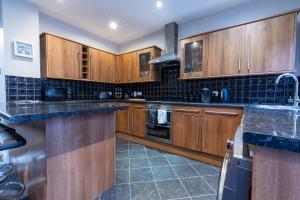 una cocina con armarios de madera y encimeras de granito en 3 bedroom home and garden in North Bristol en Bristol