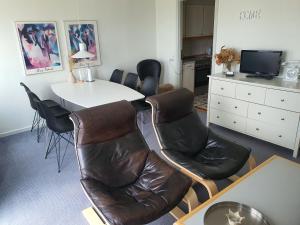 ルーケベングにあるPrivate Apartment Skudehavenのテーブルと椅子、白いテーブルとテーブルと椅子が備わる客室です。