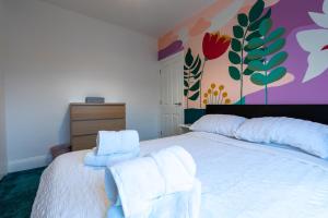Un dormitorio con una cama blanca con toallas. en 3 bedroom home and garden in North Bristol en Bristol