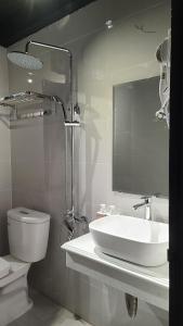 a bathroom with a sink and a toilet and a mirror at Hanoi Lucky Hostel in Hanoi