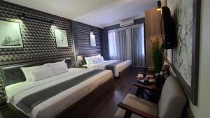 a hotel room with two beds and a chair in it at Hanoi Lucky Hostel in Hanoi
