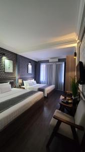 a hotel room with two beds and a television at Hanoi Lucky Hostel in Hanoi