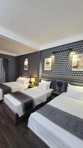 a hotel room with three beds in a room at Hanoi Lucky Hostel in Hanoi