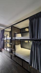 two bunk beds are in a room with curtains at Hanoi Lucky Hostel in Hanoi