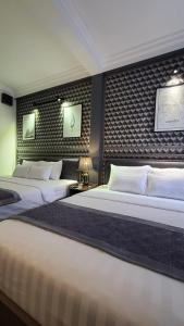 a bedroom with two beds and a wall with two posters at Hanoi Lucky Hostel in Hanoi