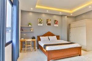 1 dormitorio con 1 cama y 1 mesa con silla en Light House & Rooftop en Hanoi