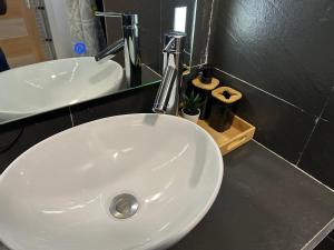 a white bathroom sink with a faucet on a counter at Charmant appartement avec terrasse, vue sur lagon in Mamoudzou