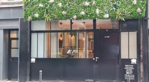 Una puerta negra de una tienda con plantas. en 153 - Urban Pretty Flat in Center of Paris, en París