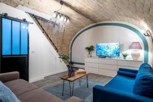sala de estar con sofá azul y TV en 153 - Urban Pretty Flat in Center of Paris, en París