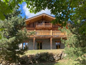 a large wooden house with a balcony on a hill at Chalet Sempre Més in Font Romeu Odeillo Via