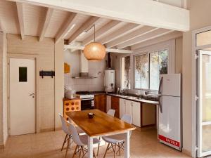a kitchen with a wooden table and a white refrigerator at Iki House in Esquel