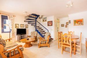 ein Wohnzimmer mit einer Wendeltreppe sowie einem Tisch und Stühlen in der Unterkunft Vivienda Agaete Paradise in Puerto de las Nieves