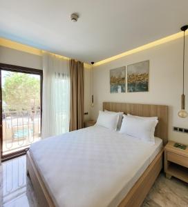 een slaapkamer met een groot wit bed en een raam bij Dna Hotel Dalyan in Dalyan