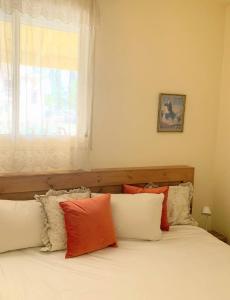 a bedroom with two beds with pillows and a window at O&B Hospitality - אירוח אלף בית in Dafna