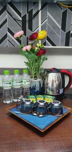 a table with a tea kettle and flowers and water bottles at Hanoi Lucky Hostel in Hanoi