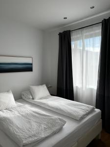 due letti in una stanza con finestra di Seydisfjördur Apartment a Seyðisfjörður