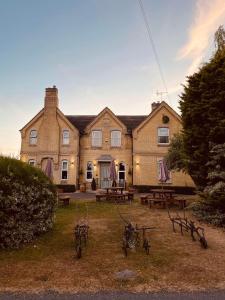 um grande edifício de tijolos com mesas de piquenique em frente em The Finch Hatton Arms em Sleaford