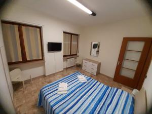 Un dormitorio con una cama azul y blanca con toallas. en VERCELLI CENTRO, en Vercelli
