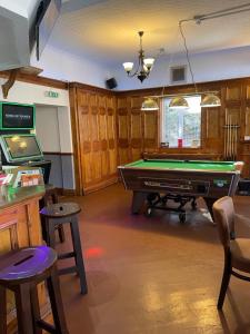 uma sala de estar com uma mesa de bilhar e uma televisão em The Swan Inn em Henwick