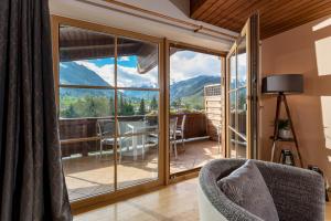 ein Wohnzimmer mit einer großen Glastür mit Aussicht in der Unterkunft Landhaus Bergner Alm in Bruck an der Großglocknerstraße + 37 Fotos