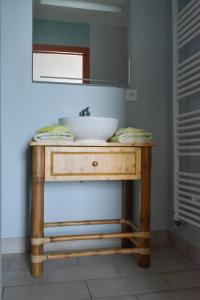 y baño con mesa de madera y lavamanos. en Domaine de Kerzuat en Plouarzel