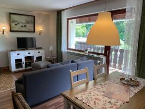 a living room with a blue couch and a table at Haus Behrendt in Zorge