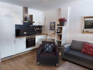 a living room with a couch and a kitchen at Sonniges Appartement am Tegernsee in Gmund am Tegernsee