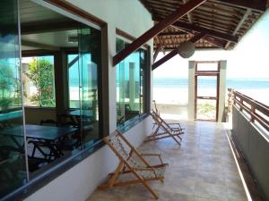 a balcony of a house with a table and chairs at Pousada Na Beira do Mar in Baía da Traição