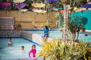 a group of children playing in a swimming pool at Ladolcevita Inland Resort in Cabadbaran